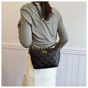 Détail du sac hobo matelassé noir avec chaîne dorée et fermoir métallique élégant