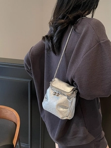 Silver mini crossbody bucket bag with metallic pleated texture and kiss-lock closure