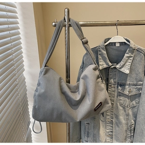 Detail of grey corduroy shoulder bag texture and Ziyouse brand patch on a minimalist tote