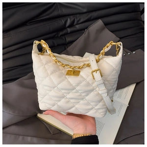 Détail du sac fourre-tout blanc matelassé avec fermoir doré et bandoulière chaîne