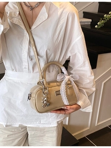 Fashion beige bowling handbag with heart charms and lace bow in a lifestyle setting