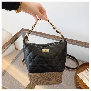 Détail du sac à main en cuir matelassé noir avec chaîne dorée et fermoir pivotant