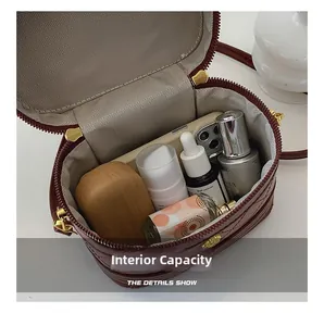 Top view of spacious interior of burgundy quilted box bag with phone and cosmetics