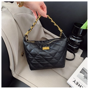 Détail d'un sac à main en cuir matelassé noir avec chaîne dorée et fermoir rotatif