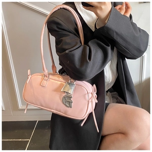 Detailed view of pink patent leather bag featuring silver hardware and letter pendant