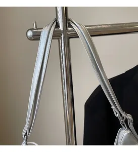 Detail of a metallic silver bag strap with neat stitching and adjustable metal buckle