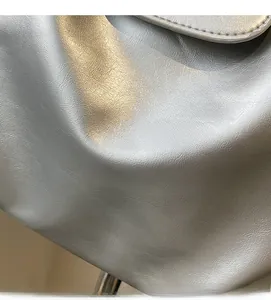 Detailed close-up of metallic silver tote bag fabric with textured lychee grain finish