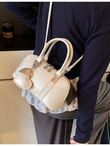 White glossy Boston handbag with Medrana logo and heart charm on a shoulder strap