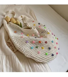 Detail of crochet hand-woven tote bag with colorful acrylic beads on cream fabric