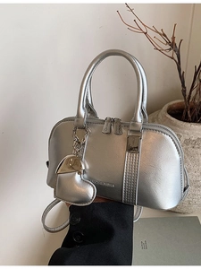 Silver metallic shell handbag with heart charm and crossbody strap for women