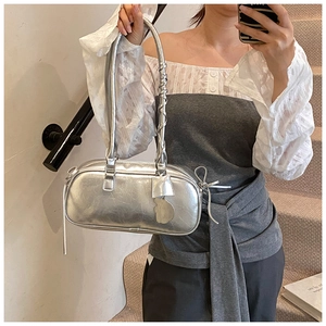 Silver metallic baguette bag with pleated texture and side tassels in a mirror selfie