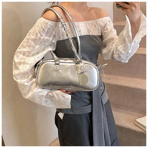 Detail of silver metallic baguette bag showing spiral handle and y2k style side tag