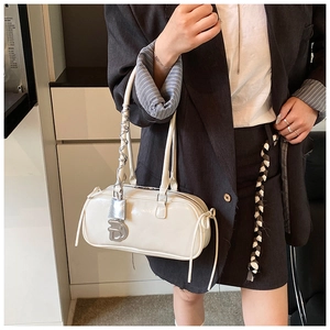 Detail view of cream white baguette bag with silver D-pendant and spiral handle