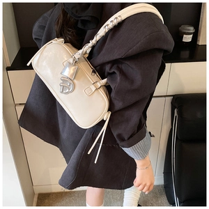 Detail of cream leather baguette bag featuring silver clasp and D-shaped metal charm