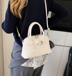 Detail showing off-white lychee texture and buckle strap on this stylish handbag