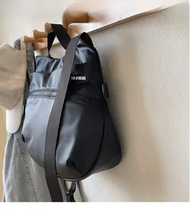 Detail of adjustable nylon strap and brand tag on black sports tote bag