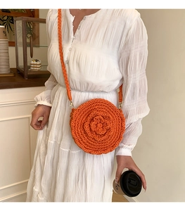 Close-up of orange crochet flower crossbody bag showing handmade woven texture