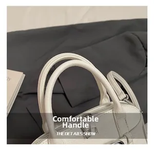 Detail of white lychee leather texture with soft handles and silver metal hardware