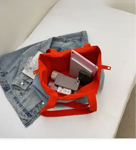 Detailed interior view of a light blue tote bag showing large capacity with orange lining