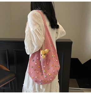 Detail of pink hand-woven crochet tote bag featuring colorful faux pearls and floral accents