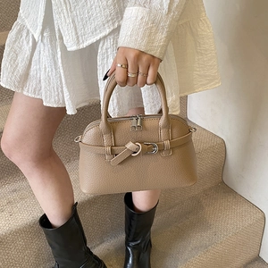 Close-up of khaki pebbled leather handbag with silver hardware and wrap-around buckle detail