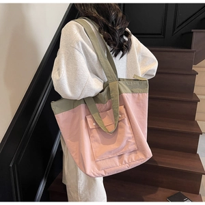 Detail of pink and olive green tote bag with large front flap pocket and white snap buttons