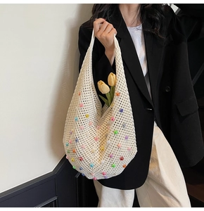 Detail of cream knit beach tote bag with colorful beads and hollow mesh pattern