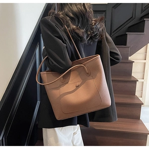 Detailansicht einer großen braunen Leder-Tote-Bag mit Litschi-Maserung an der Schulter