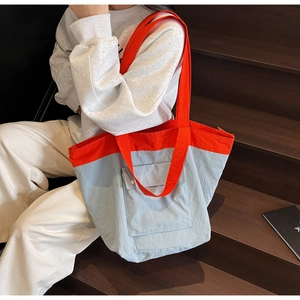 Macro shot of two-tone orange and blue-grey tote bag with front flap pocket