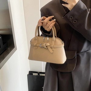 Detail of beige lychee pattern handbag with stylish belt buckle and double zipper
