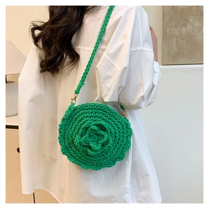 Detail of hand-woven bright green round crochet crossbody bag with 3D flower pattern