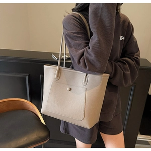 Detailaufnahme der taupefarbenen Shopper-Tasche mit Litschistruktur und Fronttasche