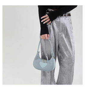 Detail of light blue heart hobo bag with gold bead zipper and twill leather texture