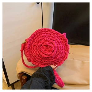 Λεπτομέρεια χειροποίητης πλεκτής στρογγυλής τσάντας με τρισδιάστατο τριαντάφυλλο σε ματζέντα