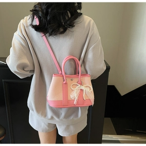 Detail view of pink patchwork crossbody bag with lace bow and pearl decoration