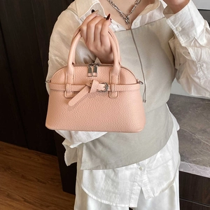 Close-up of nude pink lychee grain leather boston bag with silver dual zippers