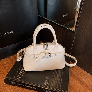Detail of white lychee-patterned bag with decorative belt knot and silver zipper