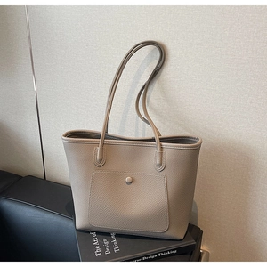 Detailansicht der taupefarbenen Ledertasche mit Vordertasche und Metallschließe am Riemen