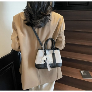 Detail of canvas and leather contrast handbag with elegant lace pearl bow charm decoration