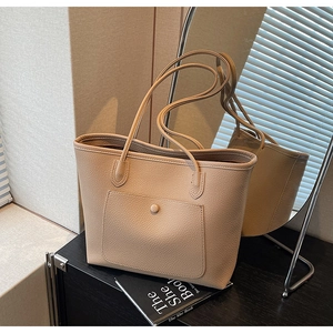 Detail der beigen Shopper-Tasche mit Lychee-Prägung und vorderer Druckknopftasche