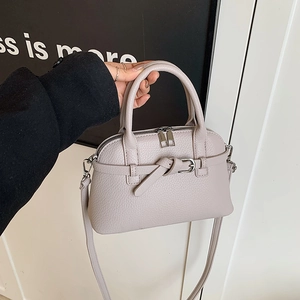 Detailed view of lychee pattern leather handbag with metal zipper and buckle