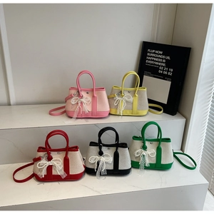 Close-up of five mini canvas handbags with lace bows and pearl details in various colors