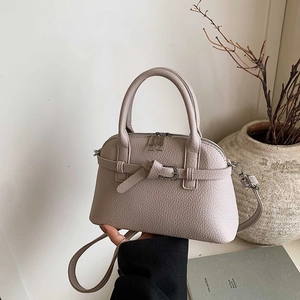 Detail of elegant beige shell bag with lychee grain leather and decorative strap buckle