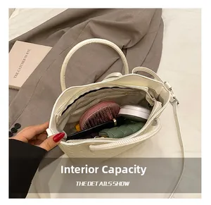 Top view showing internal capacity of white quilted bucket bag with various accessories