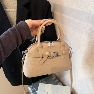 Detail of beige lychee grain leather bag with double zipper and silver metal buckle