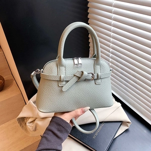 Detail of mint green lychee grain handbag with dual zippers and silver hardware