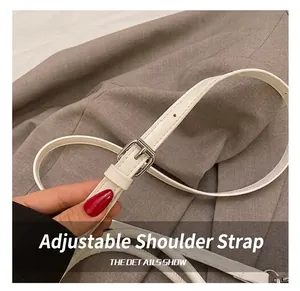 Detail of adjustable white leather strap with silver buckle and fine stitching craftsmanship