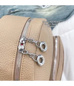 Macro view of beige lychee grain leather texture with glossy silver metal dual zippers