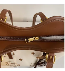 Detail of smooth gold zipper and contrast leather stitching on embroidery tote bag