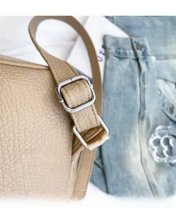 Detailed close-up of adjustable strap and silver metal buckle on soft leather backpack